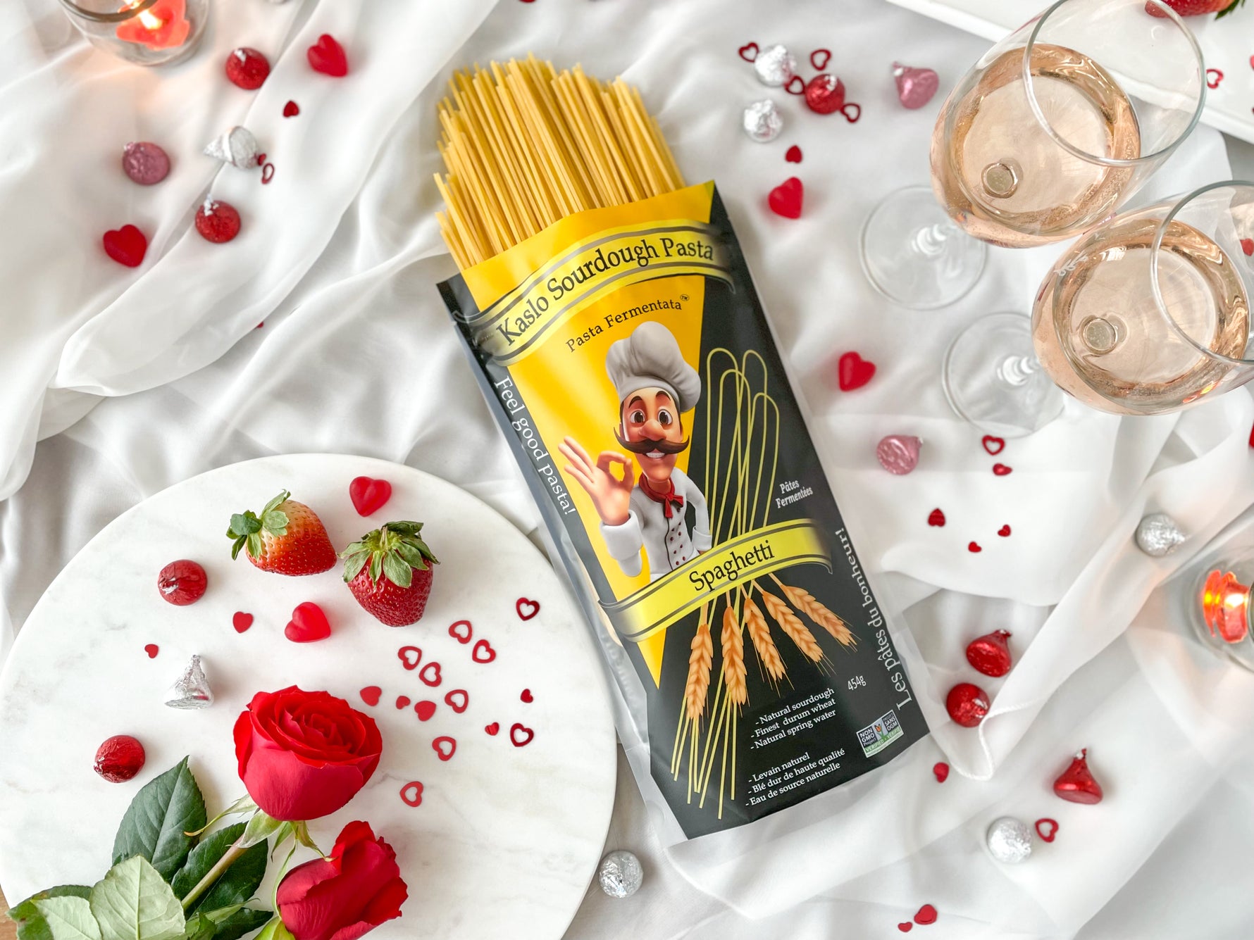 Kaslo Sourdough Pasta package with spaghetti on a Valentine's decorative table setting with flowers and glasses.